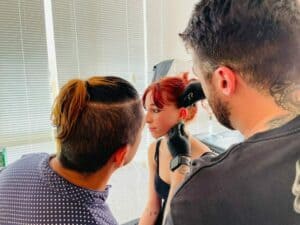 Alumno realizando práctica durante el curso de piercing en cabina profesional