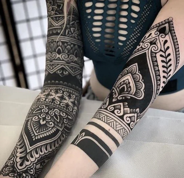 Tatuadora usa tinta negra y flores coloridas para cubrir tatuajes antiguos