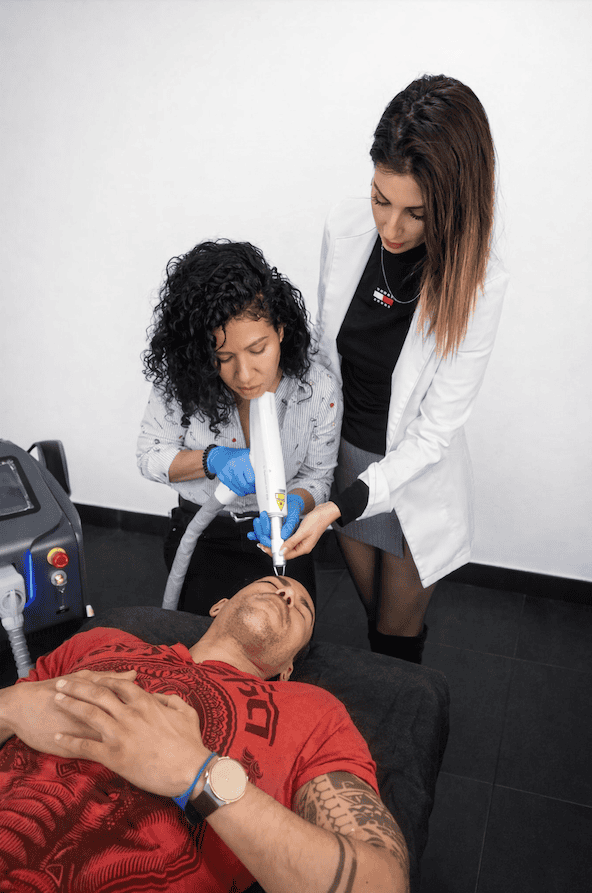 instructora realiza junto con una alumna una prácticas de eliminación de Micropigmentacion en Tattoo School Madrid