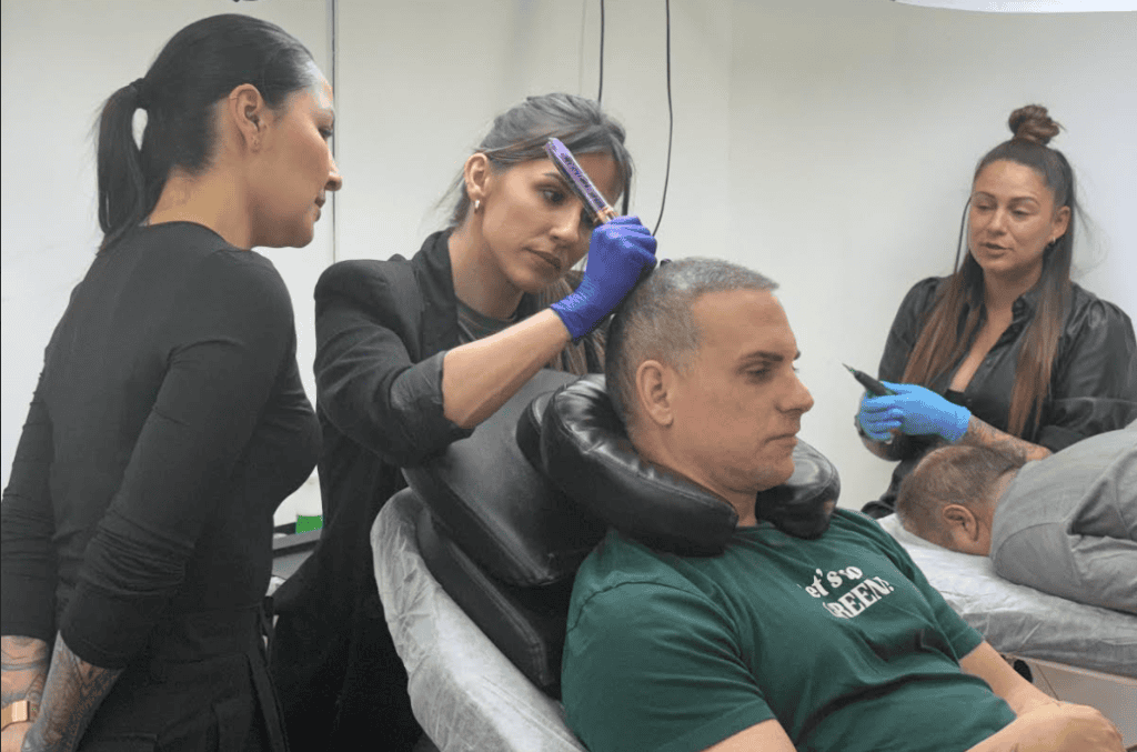 Profesora supervisando una práctica de micropigmentación capilar sobre un modelo real durante el Curso de Micropigmentación Capilar en Tattoo School Madrid.