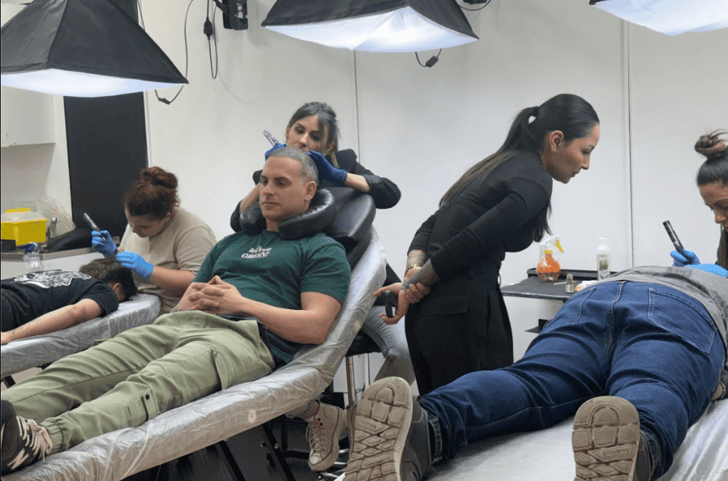 Alumnos realizando prácticas reales de micropigmentación capilar sobre modelos durante el Curso de Micropigmentación Capilar en Tattoo School Madrid.